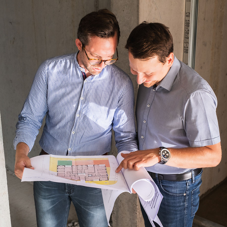 Marcus Tröbs und Daniel Schuster besprechen einen Bauplan